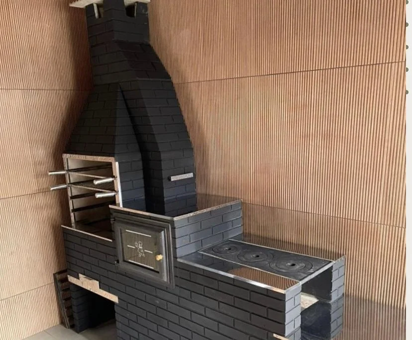 Churrasqueira pré-moldada com forno e fogão em acabamento escuro, executada pela Nova Stone